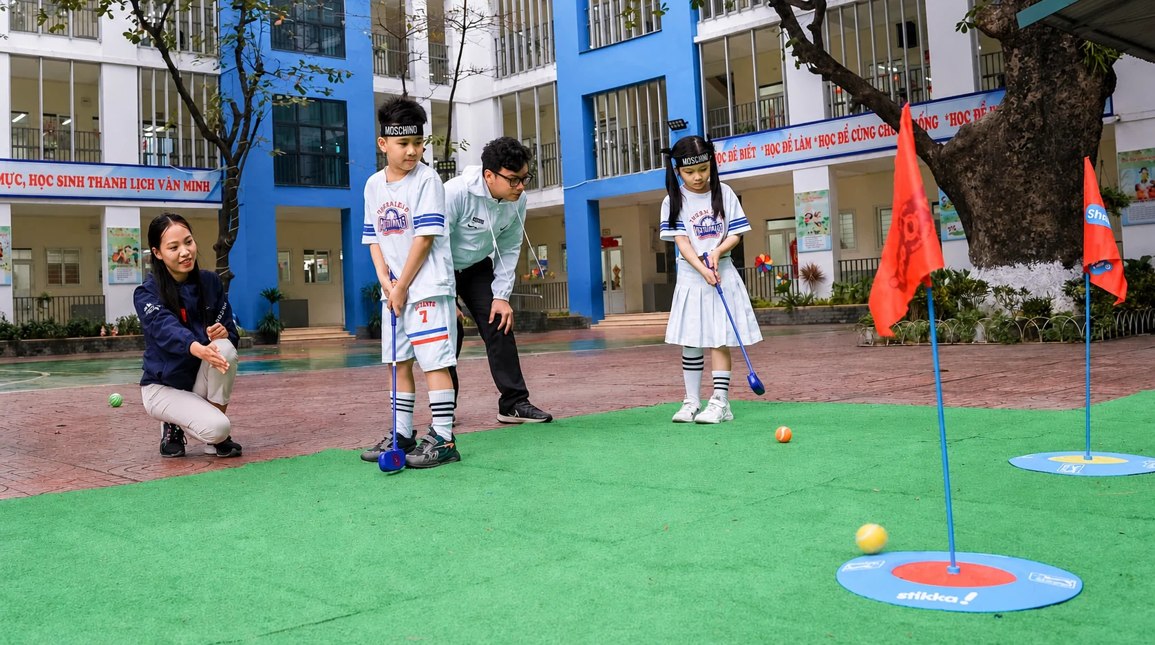 Huong dan vien va hoc vien nho tuoi tap cu danh SNAG Golf ngoai troi